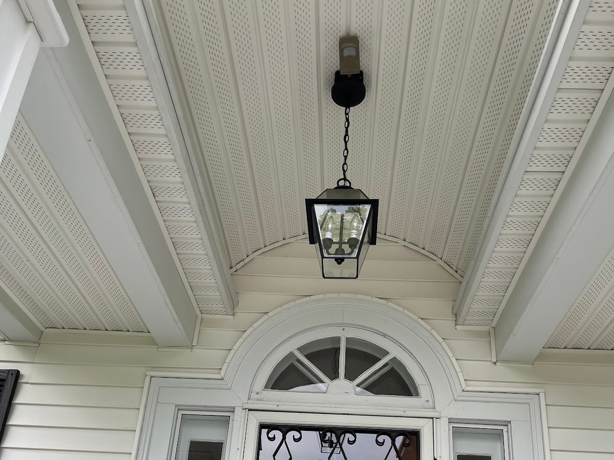 Hanging entry lantern and wall sconce installed over a front door by Chair City Electric